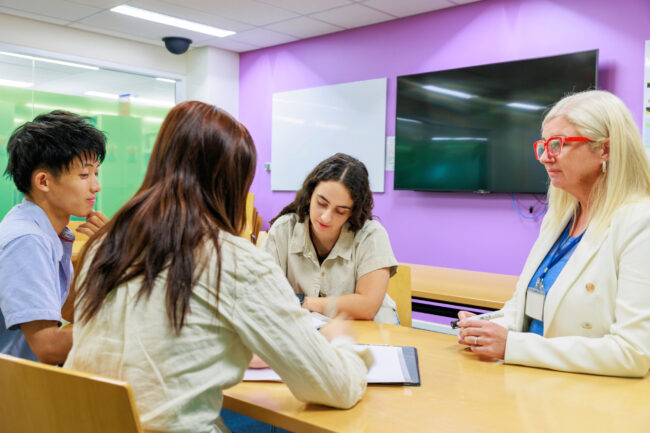 外国人講師から勉強を教えてもらう学生