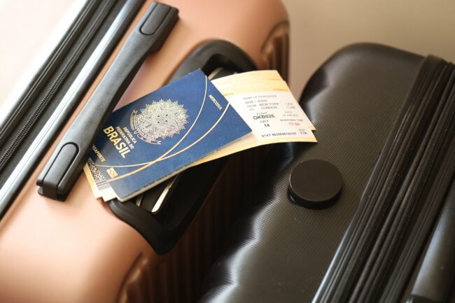 Federative Republic of Brazil passport with tickets lies on touristic suitcase in airport hall