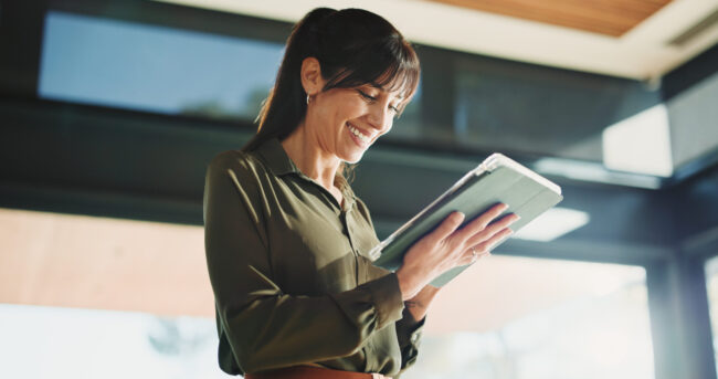 Woman, realtor and smile with tablet, property management or service review in office. Below, mature estate agent and digital tech in agency for commission update, app scroll or thinking for research